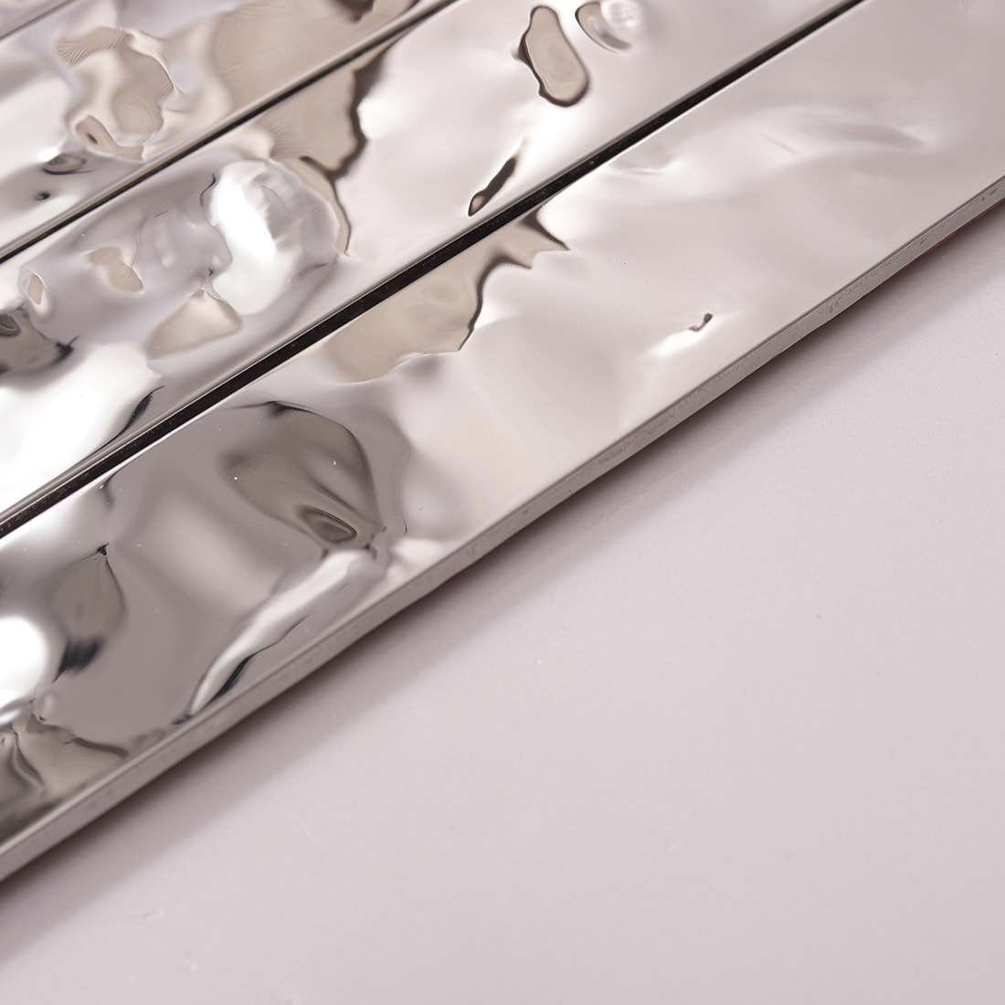 Side view showing the thickness and ripple texture of silver linear tile.