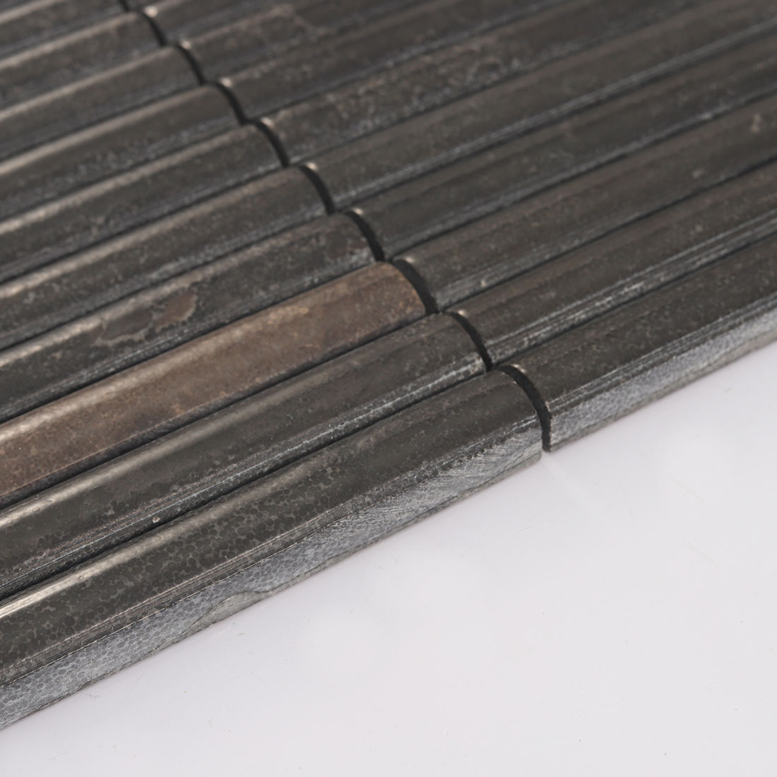 Side view of chocolate brown fluted stone mosaic tile with curved raised surface
