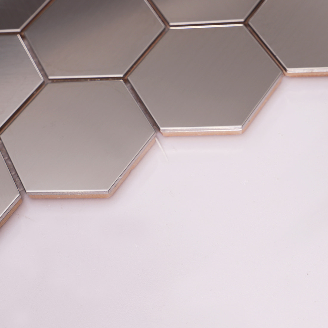 An angled side view showing the thickness and ceramic backing of the silver hexagon tiles.