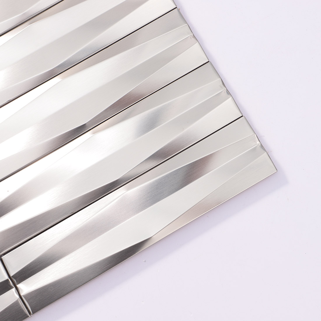 Close-up of silver 3D linear stainless steel mosaic tile corner
