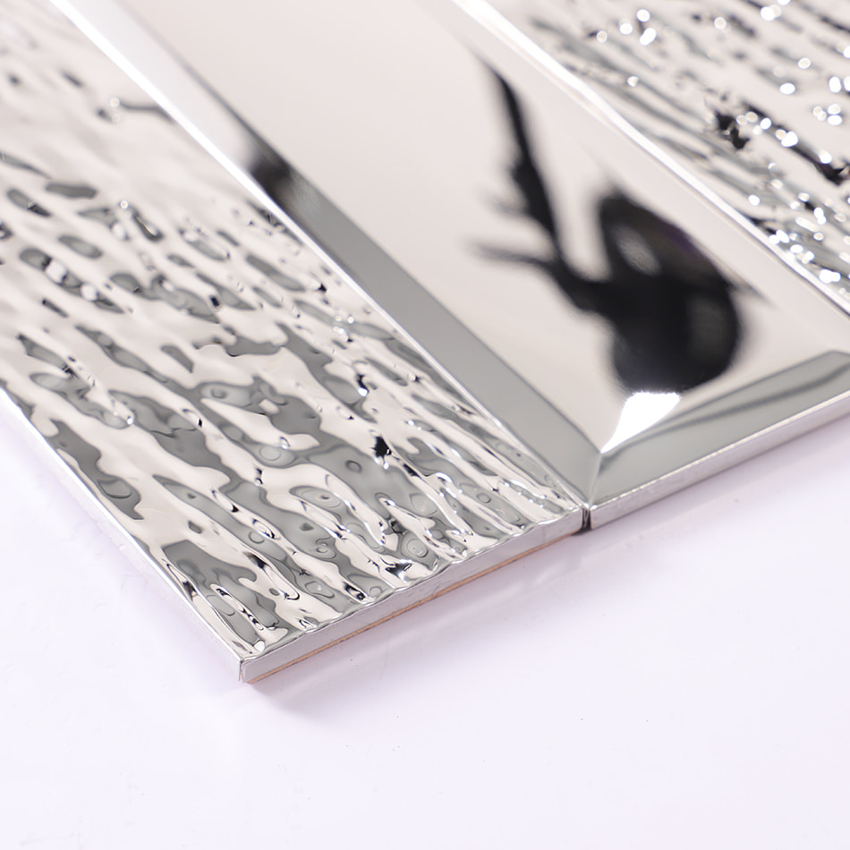 Edge detail of silver beveled textured metal wall tile
