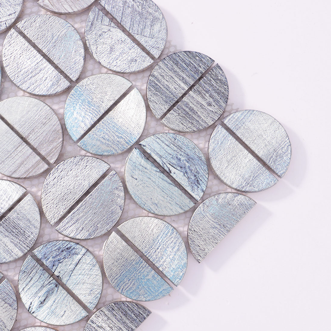 Close-up detail of silver round aluminum tile with subtle blue texture
