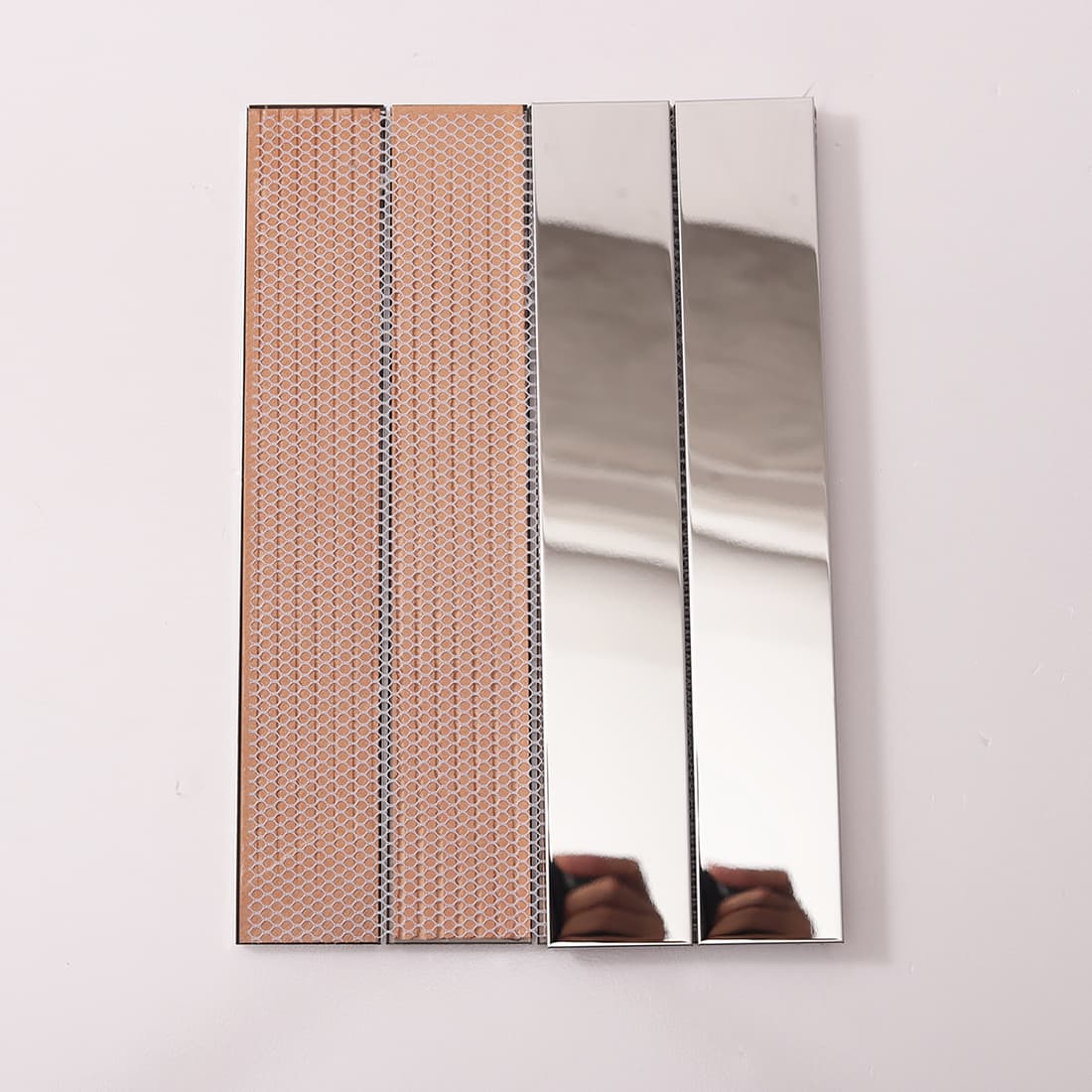 Front and back of silver linear mirror tiles showing mesh backing.