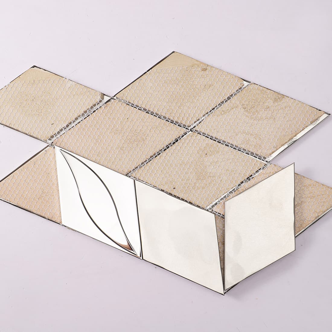 Back view of silver metal diamond tiles showing fiber mesh backing.