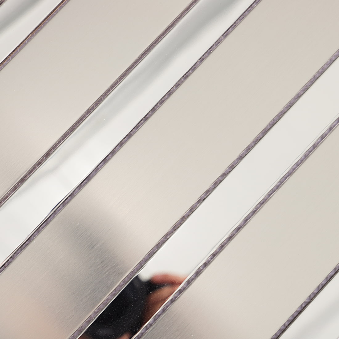 Close up of silver metal strip mosaic with brushed and reflective surfaces