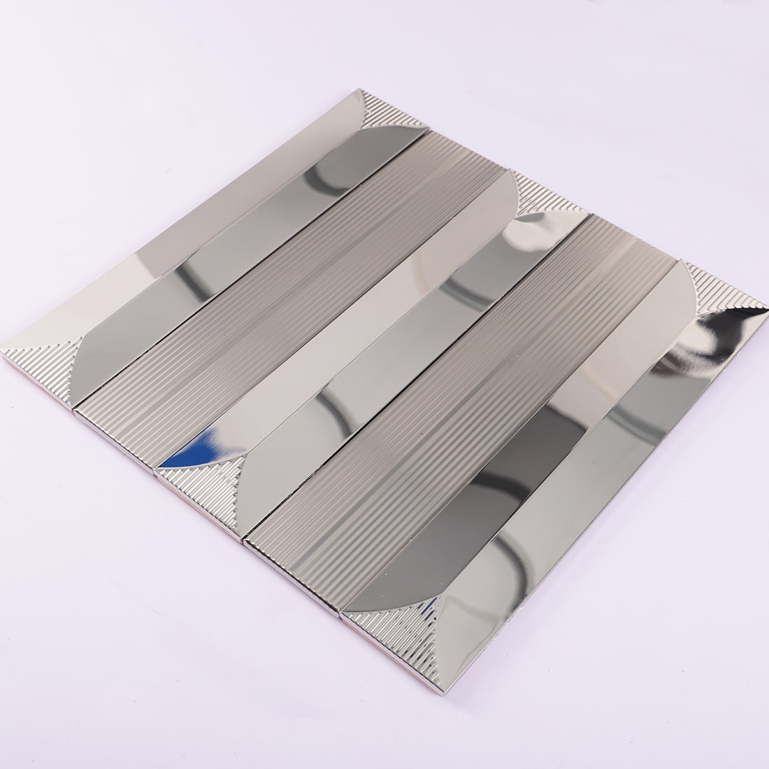 Angled view of silver mirror and fluted metal mosaic tile sheet