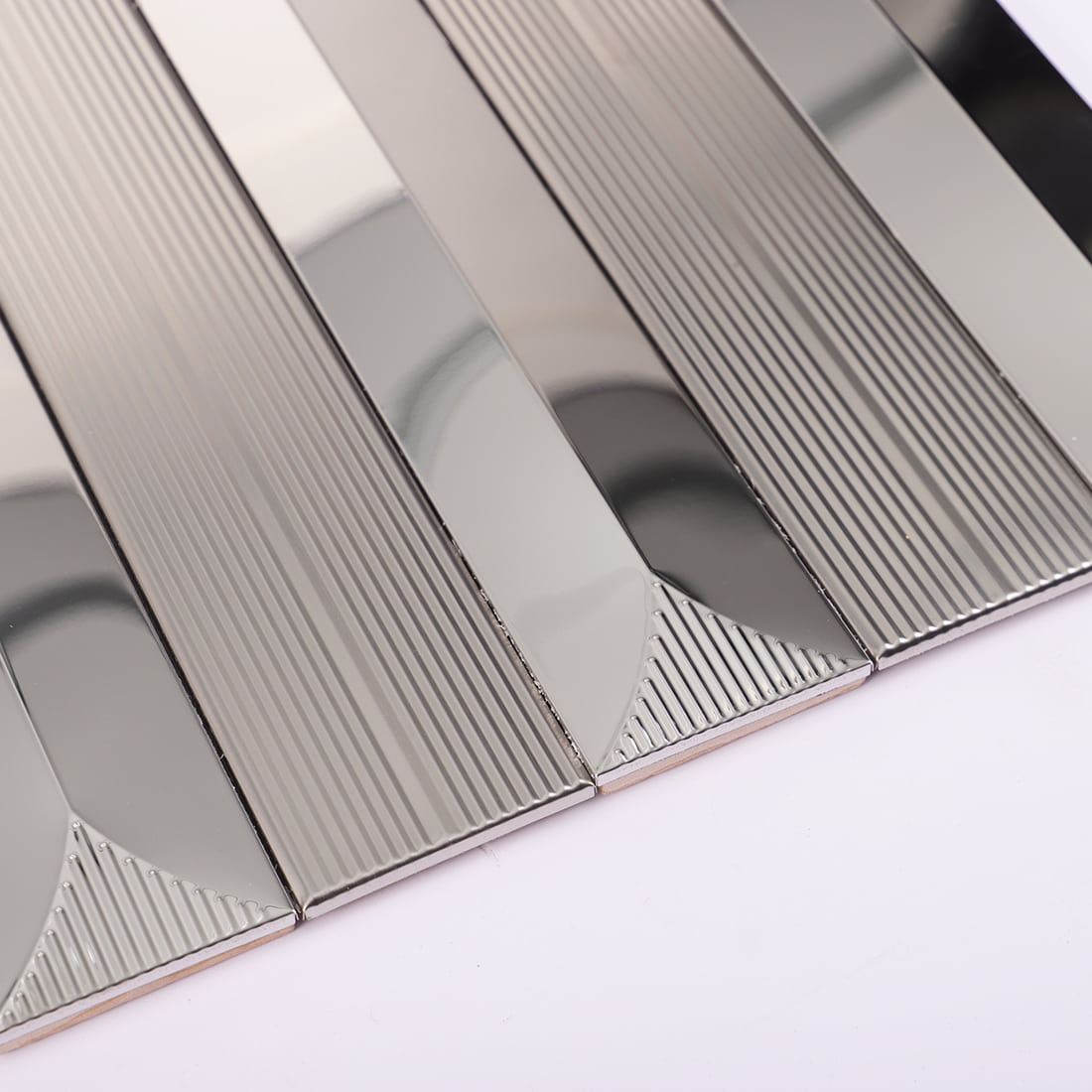 Close-up of silver mirror and fluted metal mosaic surface