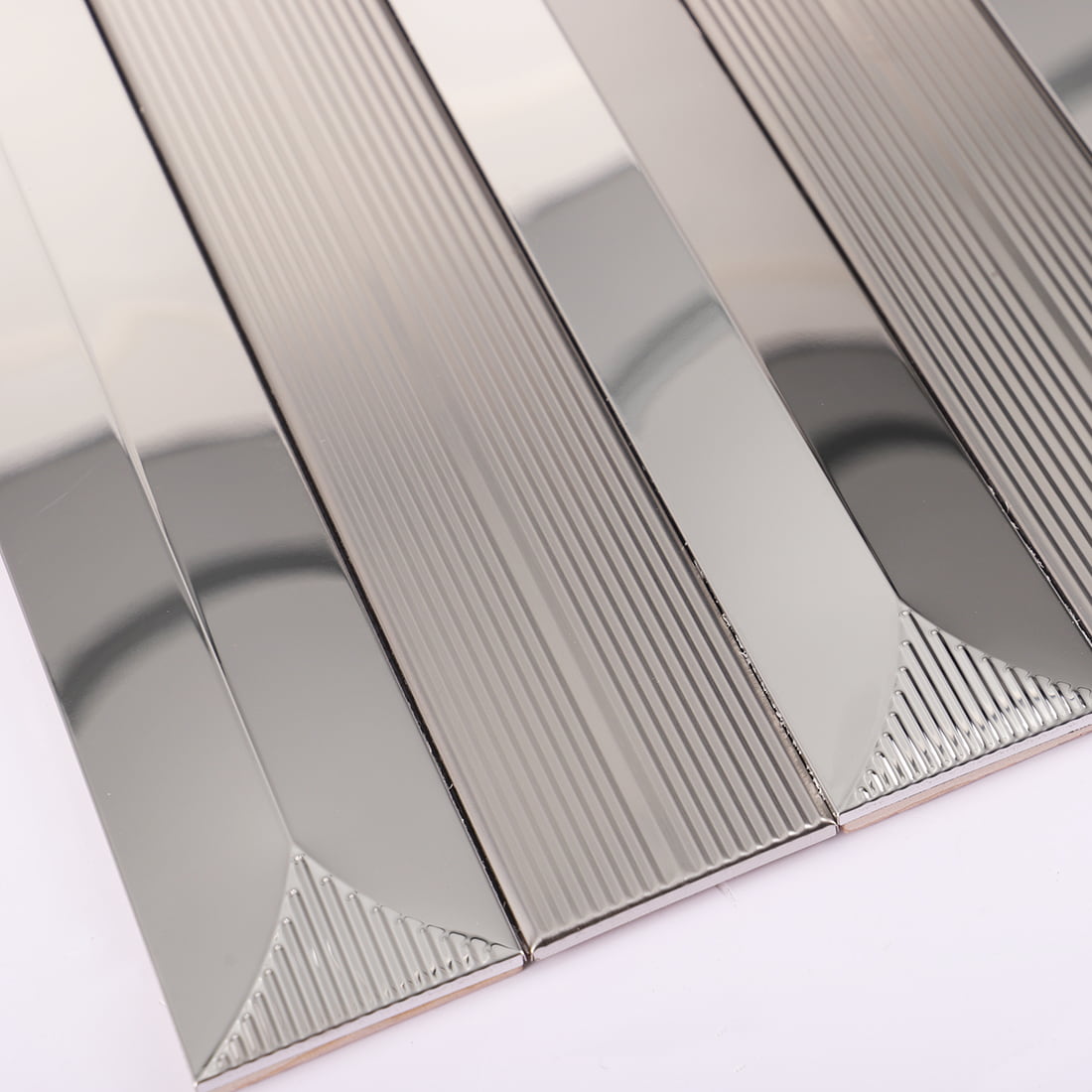 Corner detail of silver mirror and fluted metal mosaic tile