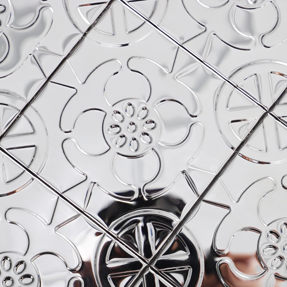Close up of silver stainless steel floral embossed mosaic tile pattern