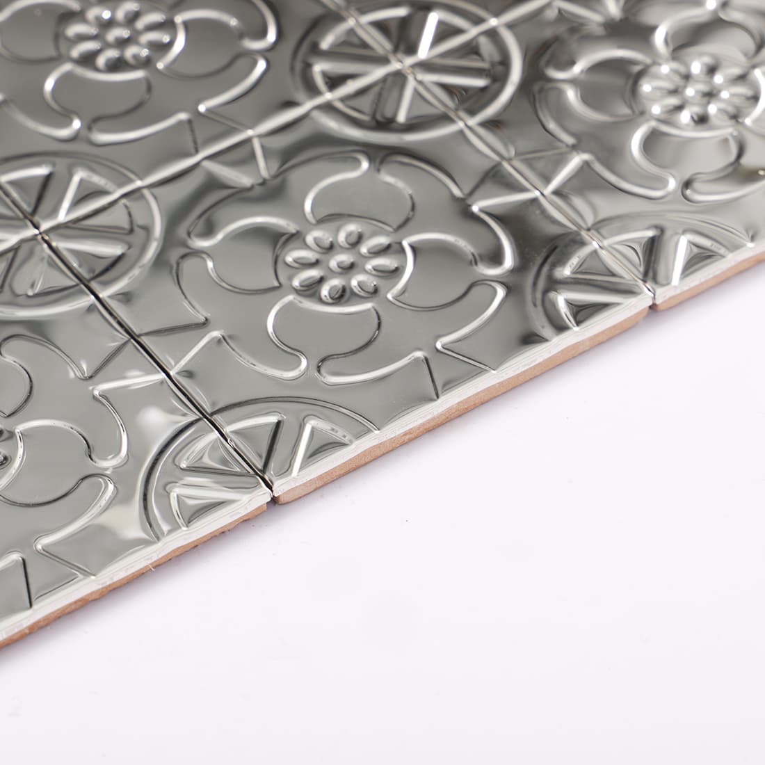 Side view of silver stainless steel floral embossed mosaic tiles