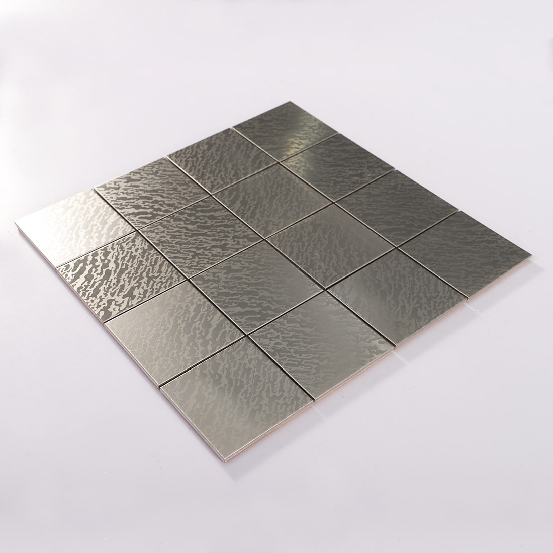 Angled view of silver stainless steel square mosaic with reflective wave pattern