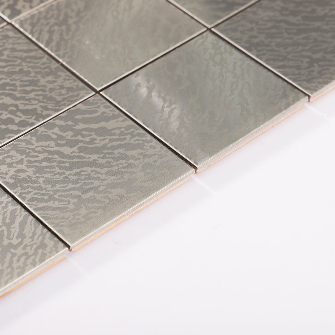 Edge detail of silver stainless steel square tile with brushed ripple finish