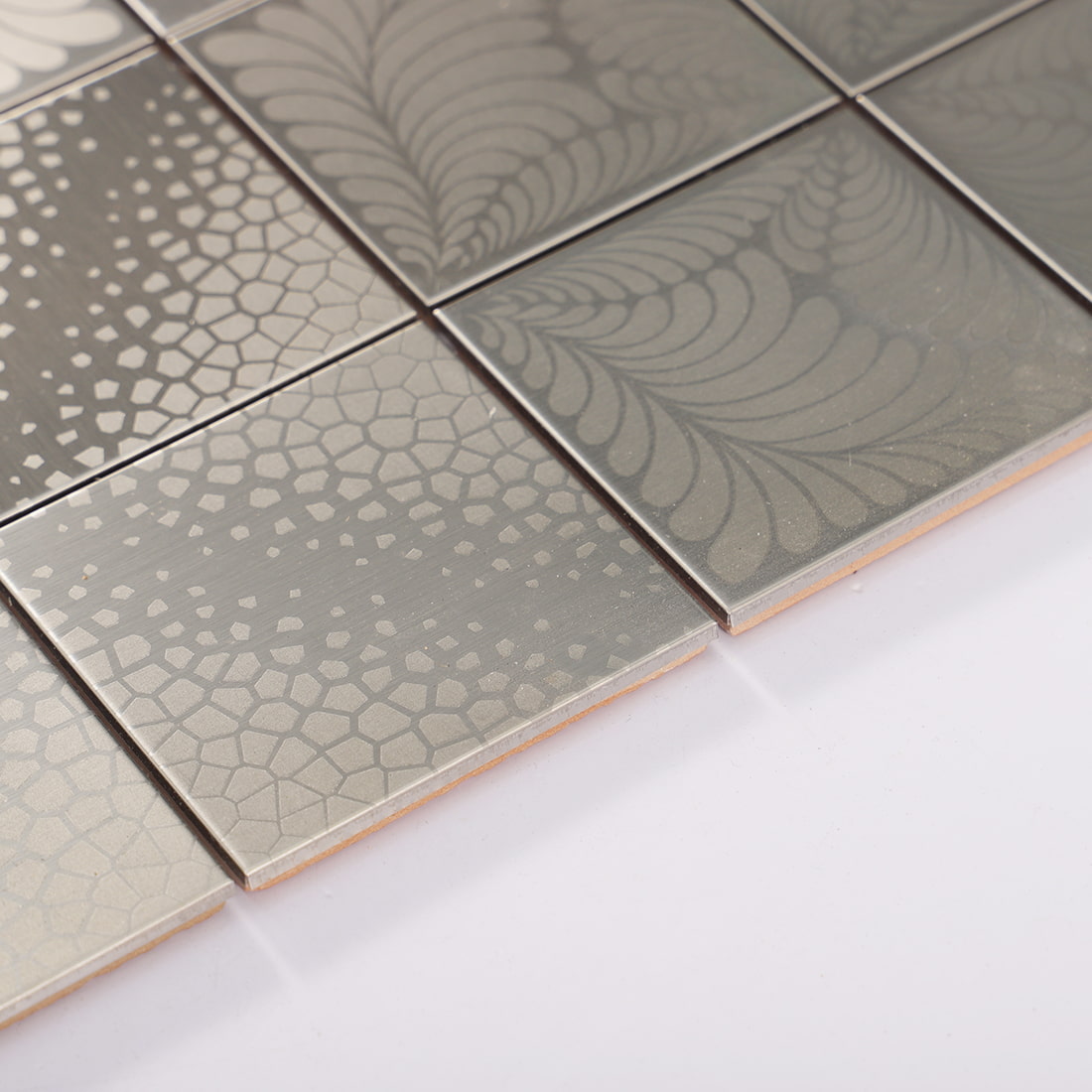 Surface detail of silver stainless steel square tile with brushed patterned finish