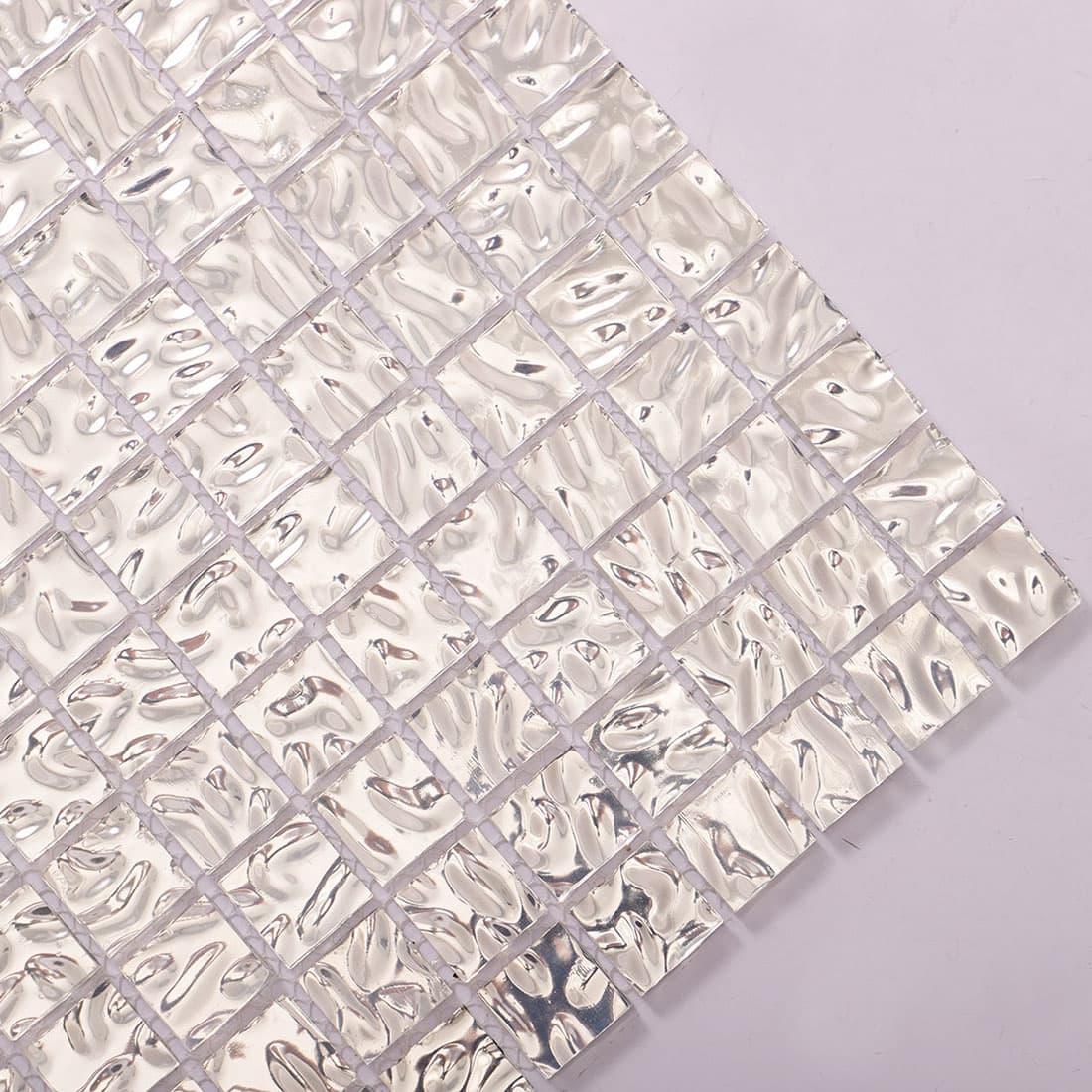 Corner detail of silver wavy 20mm square glass mosaic tile