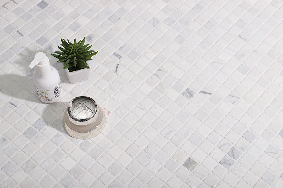 {"default":"Square white marble tiles on a bathroom floor with cosmetics and a succulent plant."}
