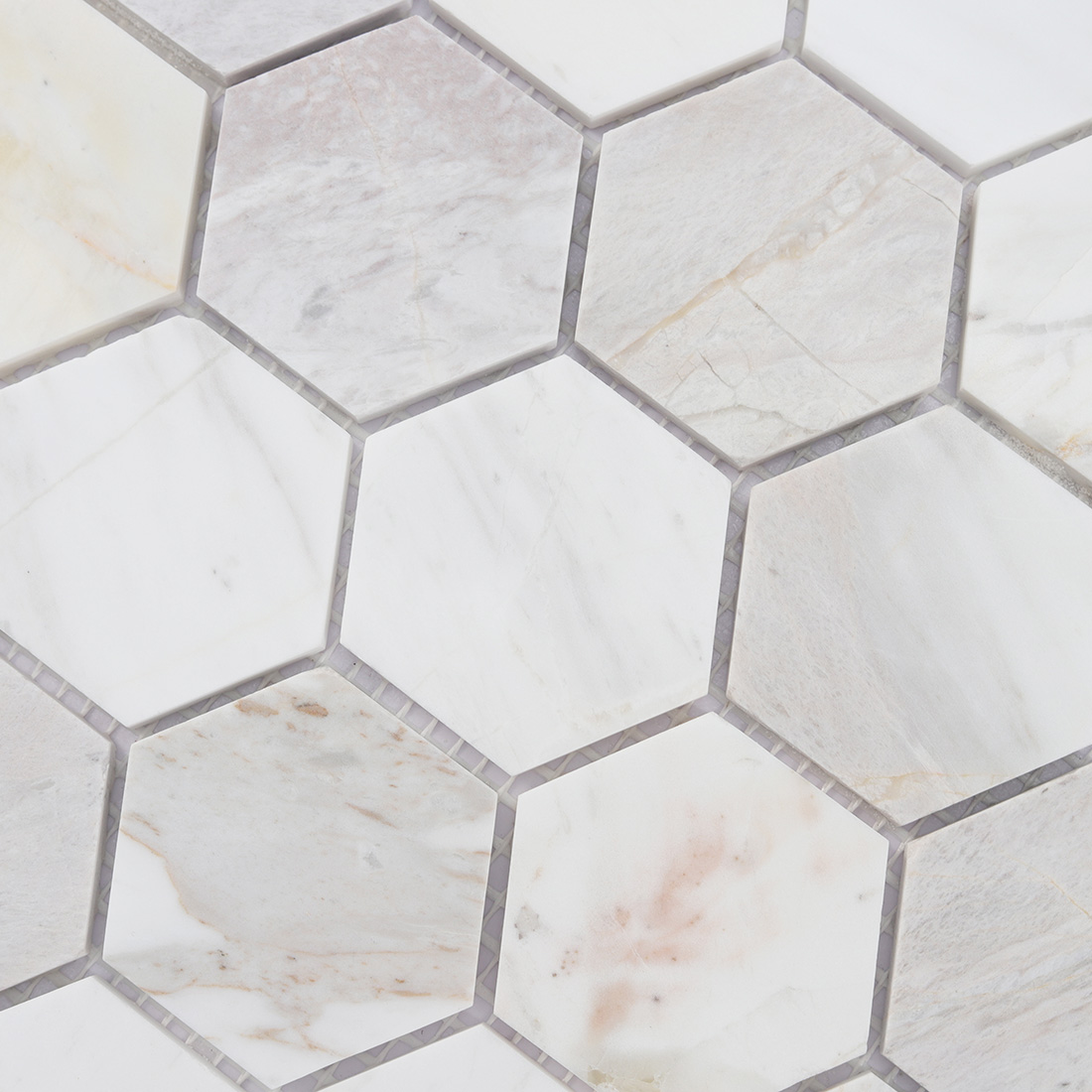 Surface detail of soft beige hexagon marble mosaic with warm stone veins