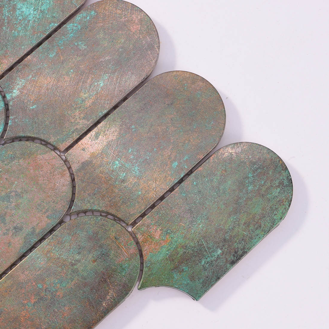 Close-up detail of verdigris bronze arched aluminum mosaic tile corner