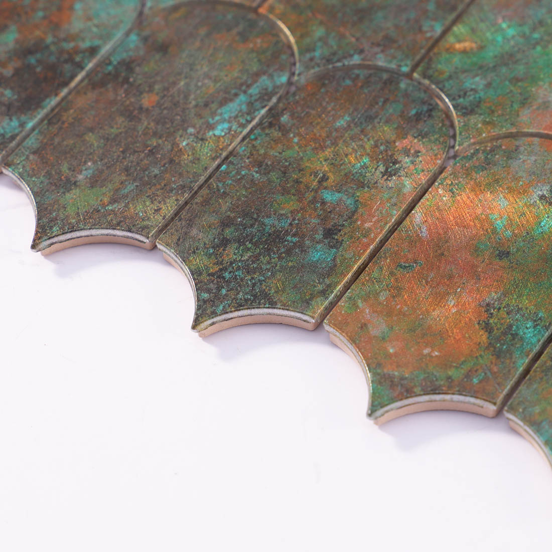 Angle shot of verdigris bronze arched aluminum mosaic tile showing edge