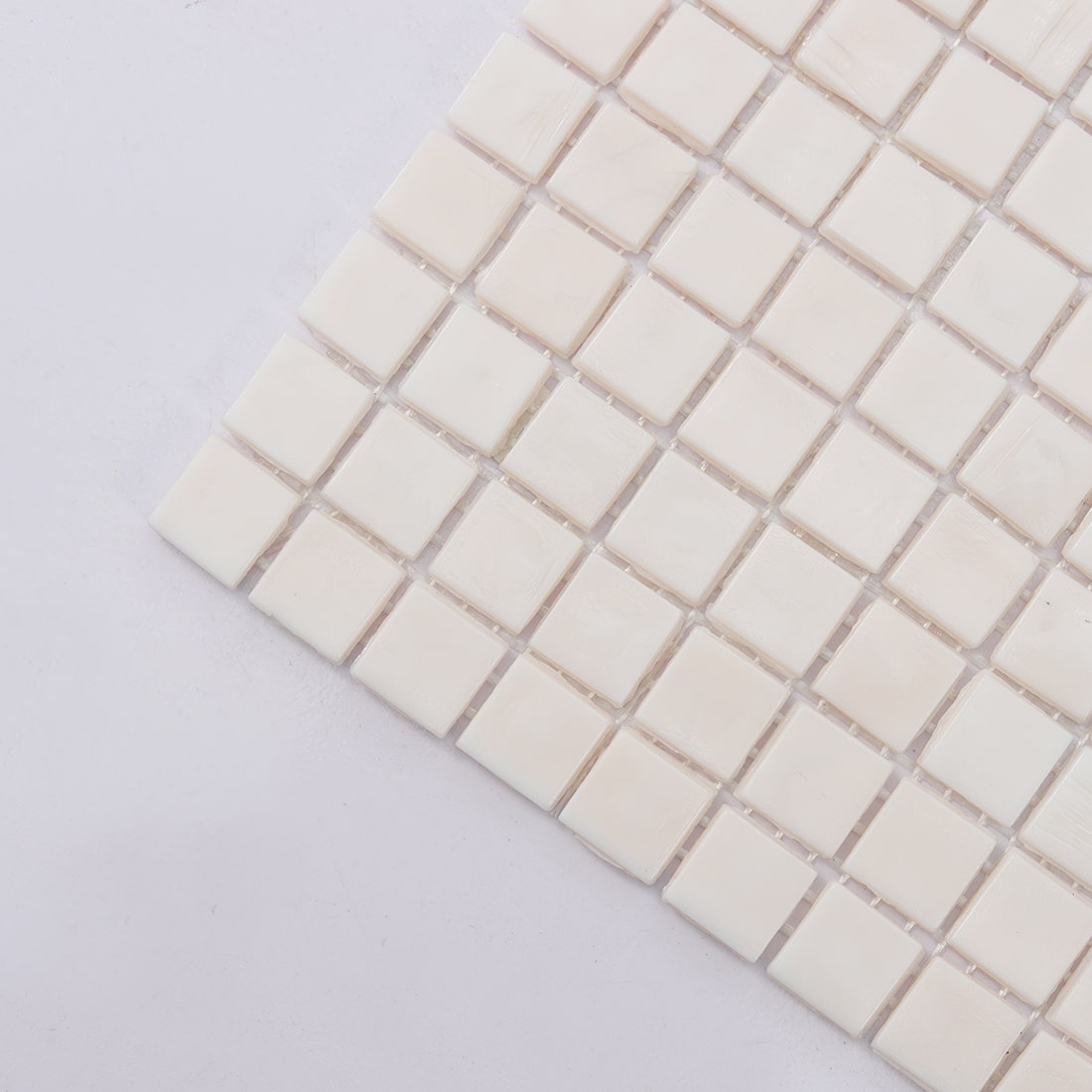 Corner view of very light pink square glass mosaic tile