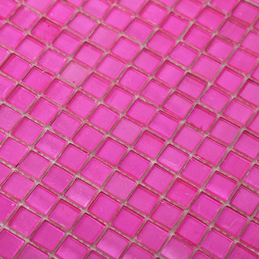 Close-up of vivid pink foil-backed square glass mosaic surface