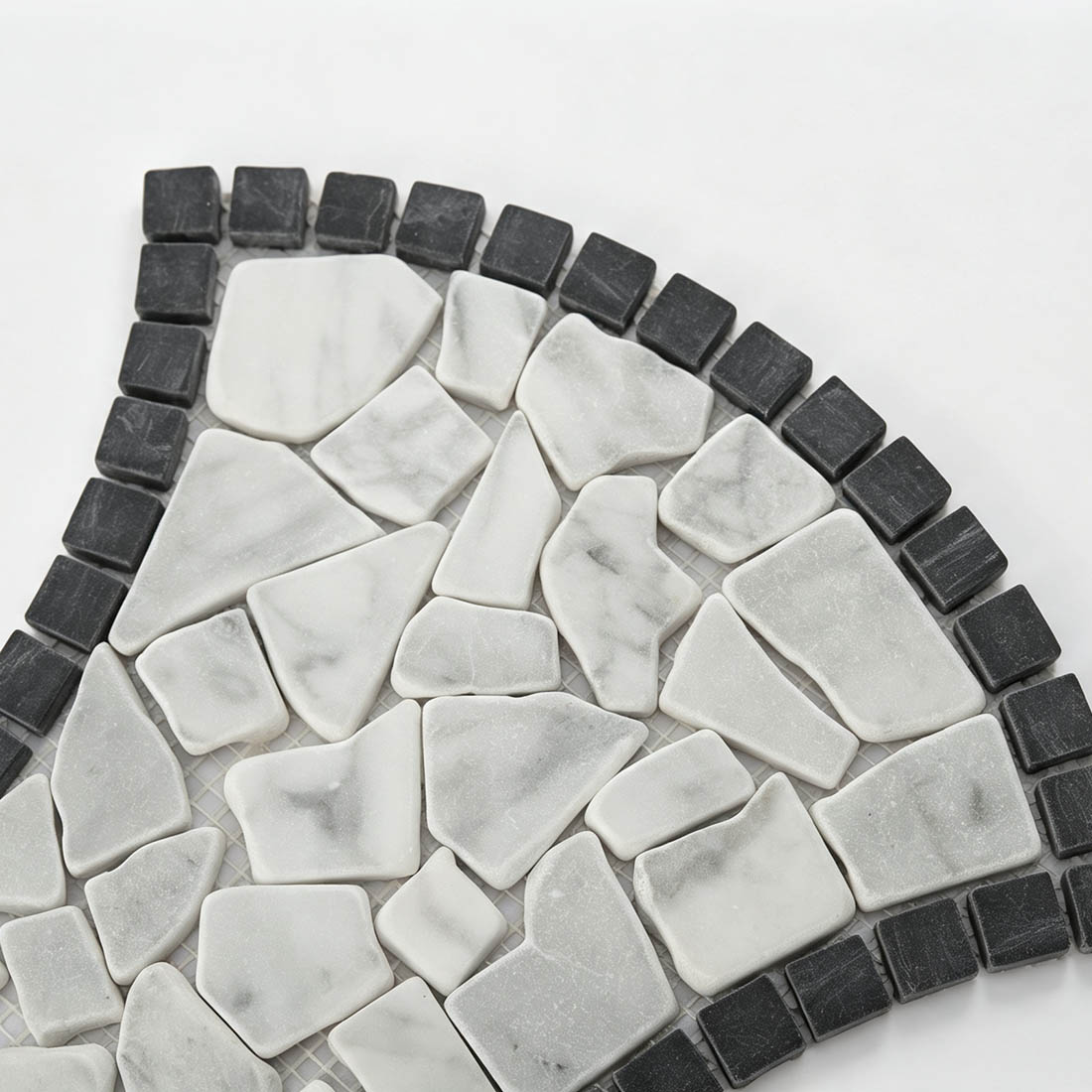Close-up of white marble pebble mosaic and black border tiles