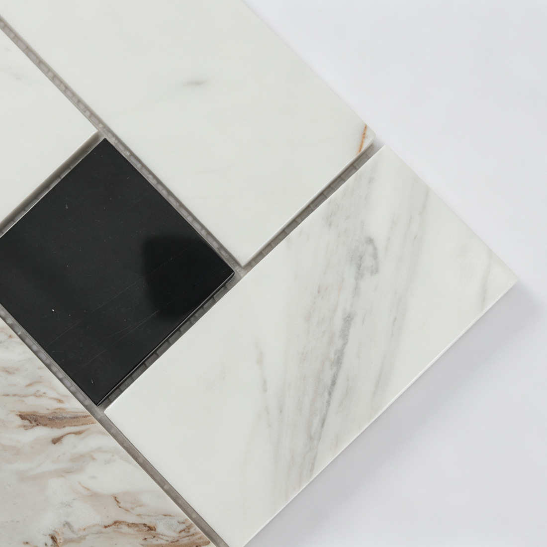 Close-up of white veined marble and black marble pieces in geometric mosaic tile