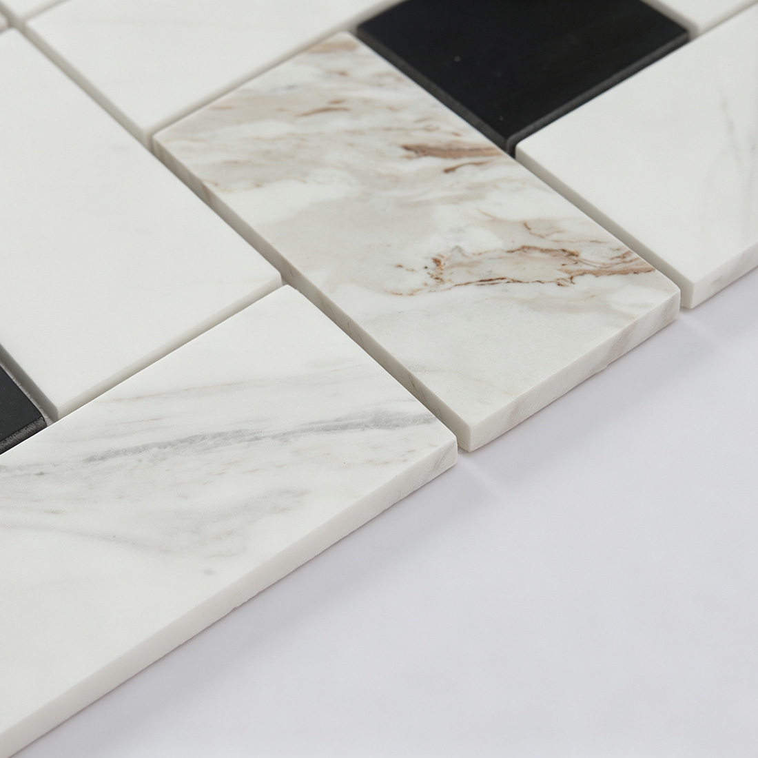 Angled detail of white and black marble geometric mosaic tile with natural stone veining