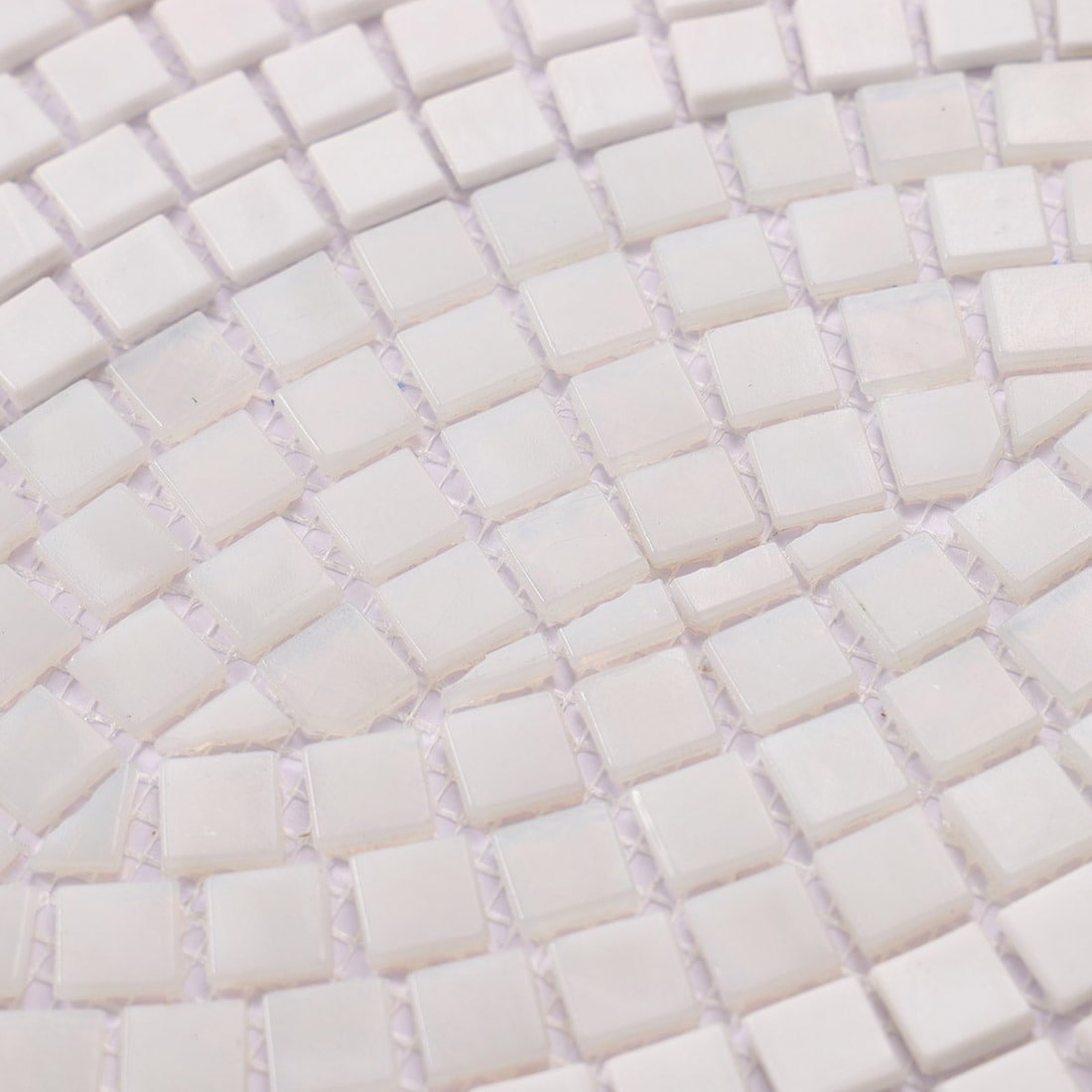 Close-up view of handcrafted white glass mosaic tiles showing texture and pattern.