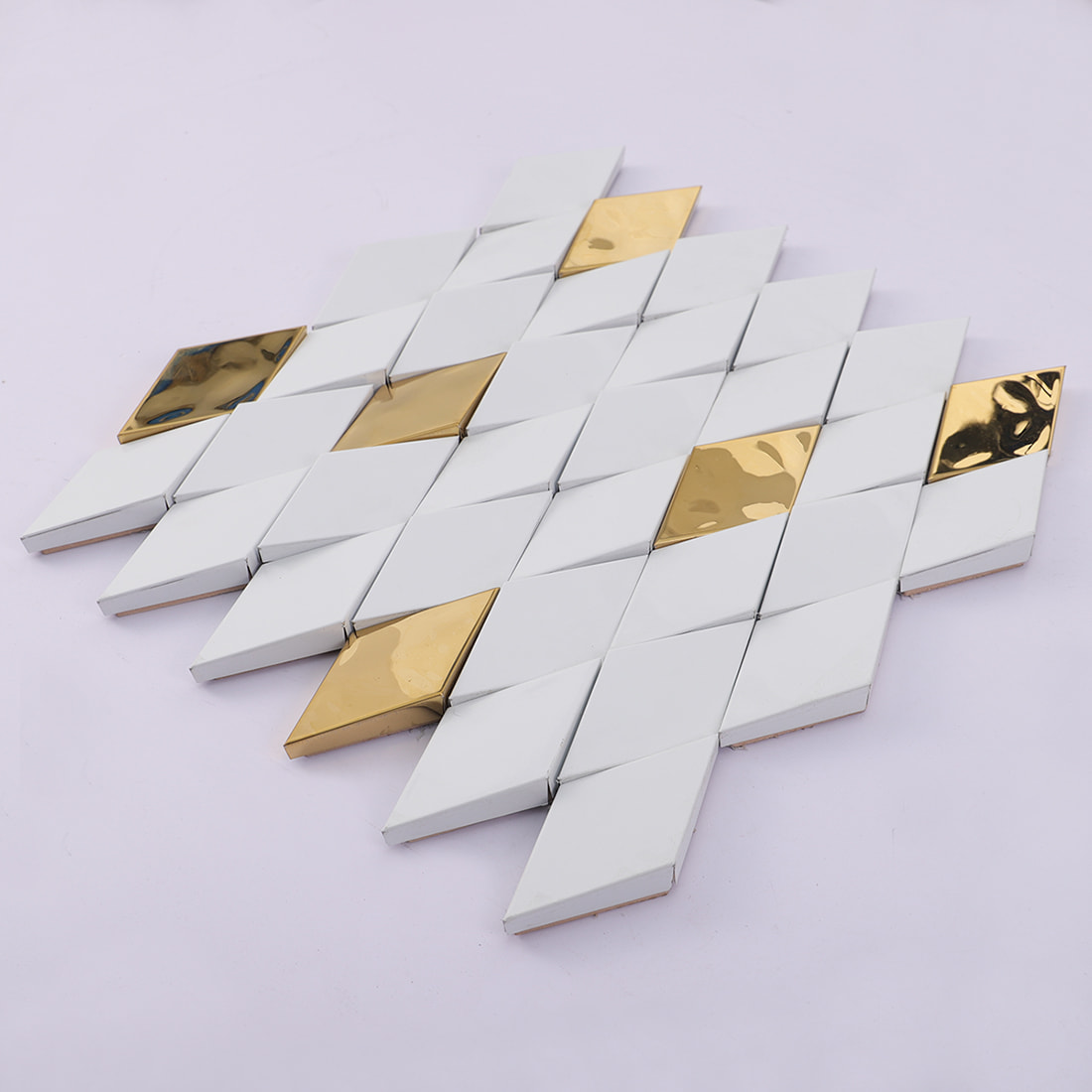 Angled view of white and gold elongated diamond mosaic tile sheet