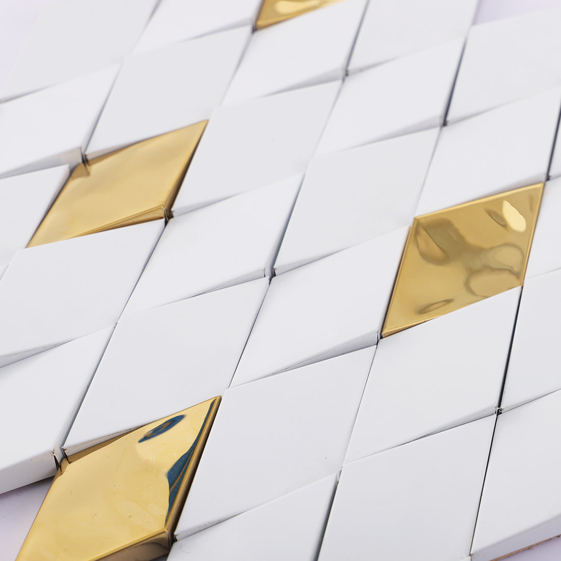 Close-up of white and gold elongated diamond mosaic tile surface