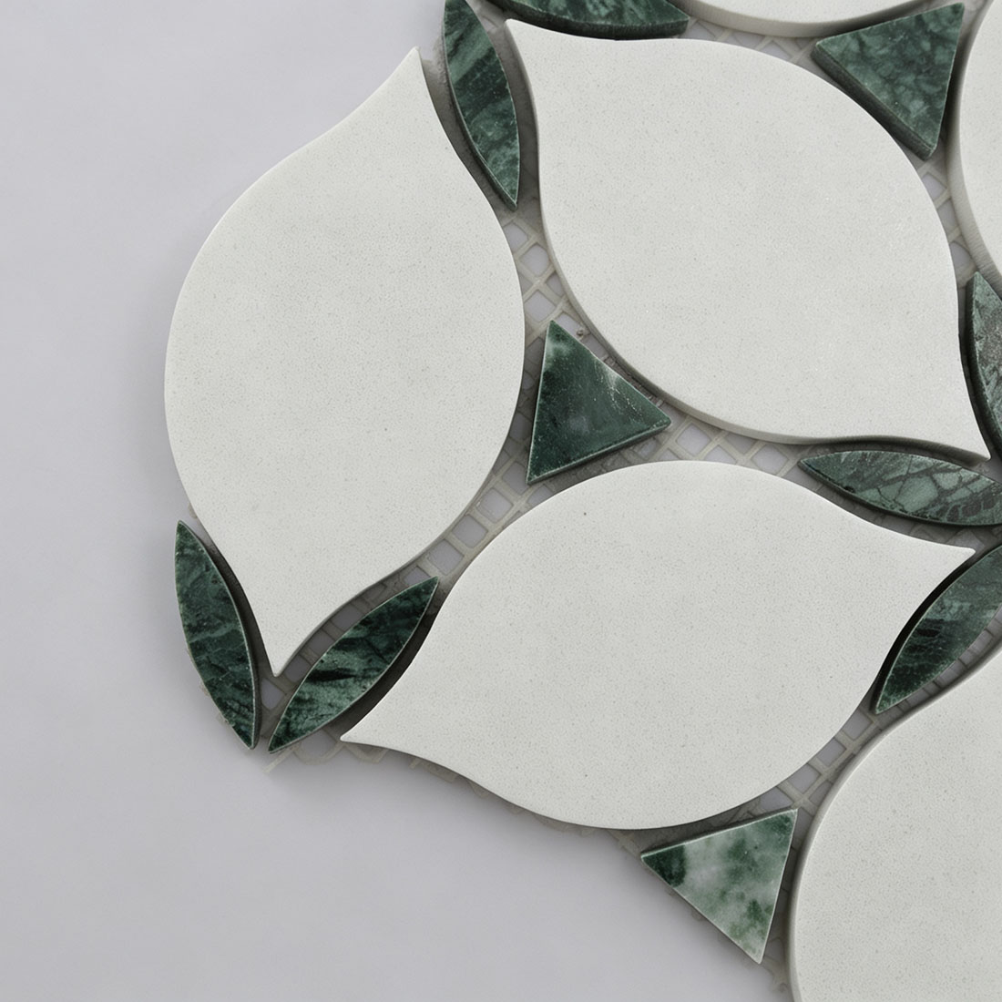 Close-up of white leaf and green marble mosaic tile pieces