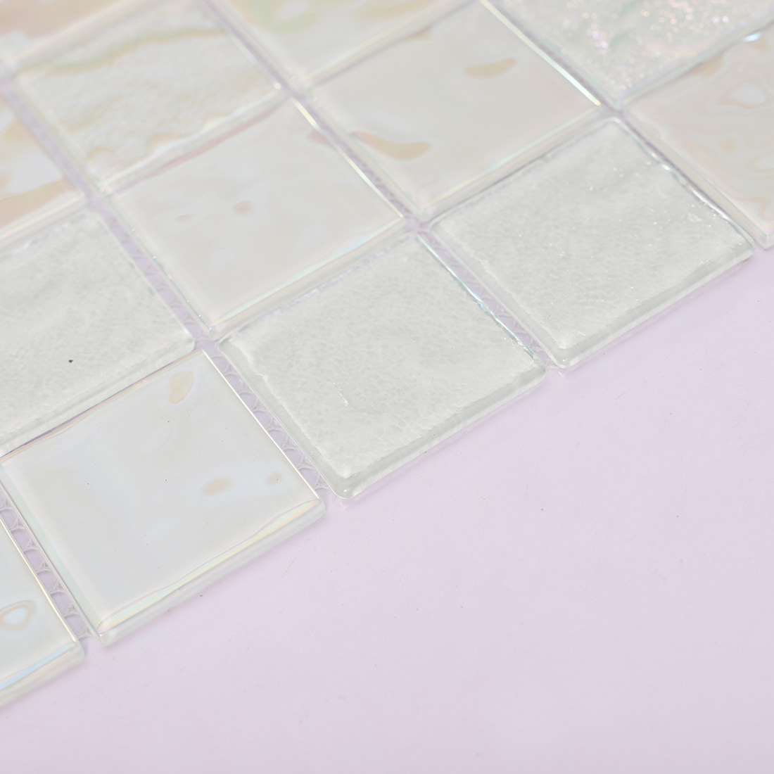 Edge detail of white iridescent square glass mosaic tile with glossy finish