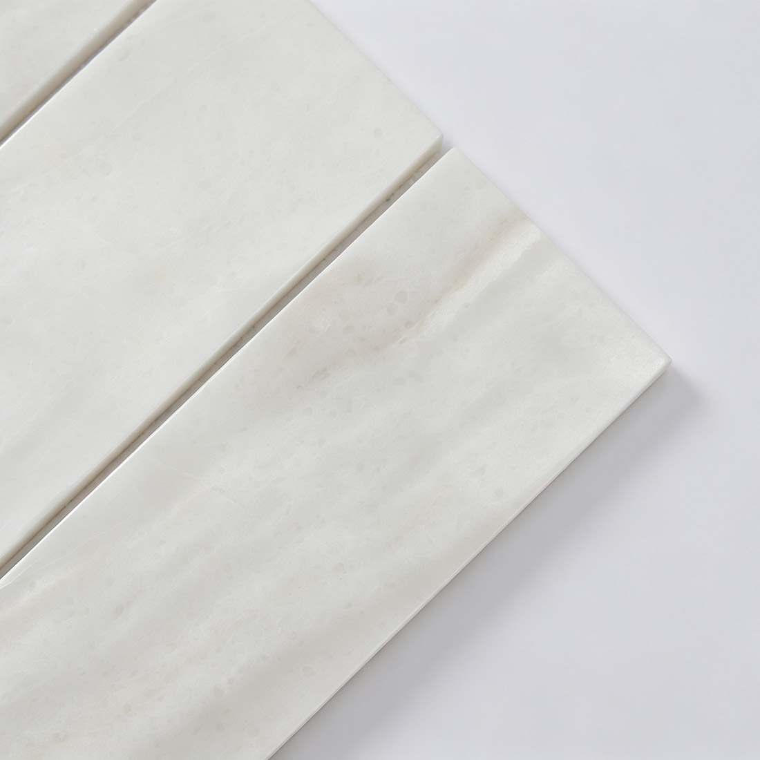 Corner detail of white linear marble mosaic tile strips