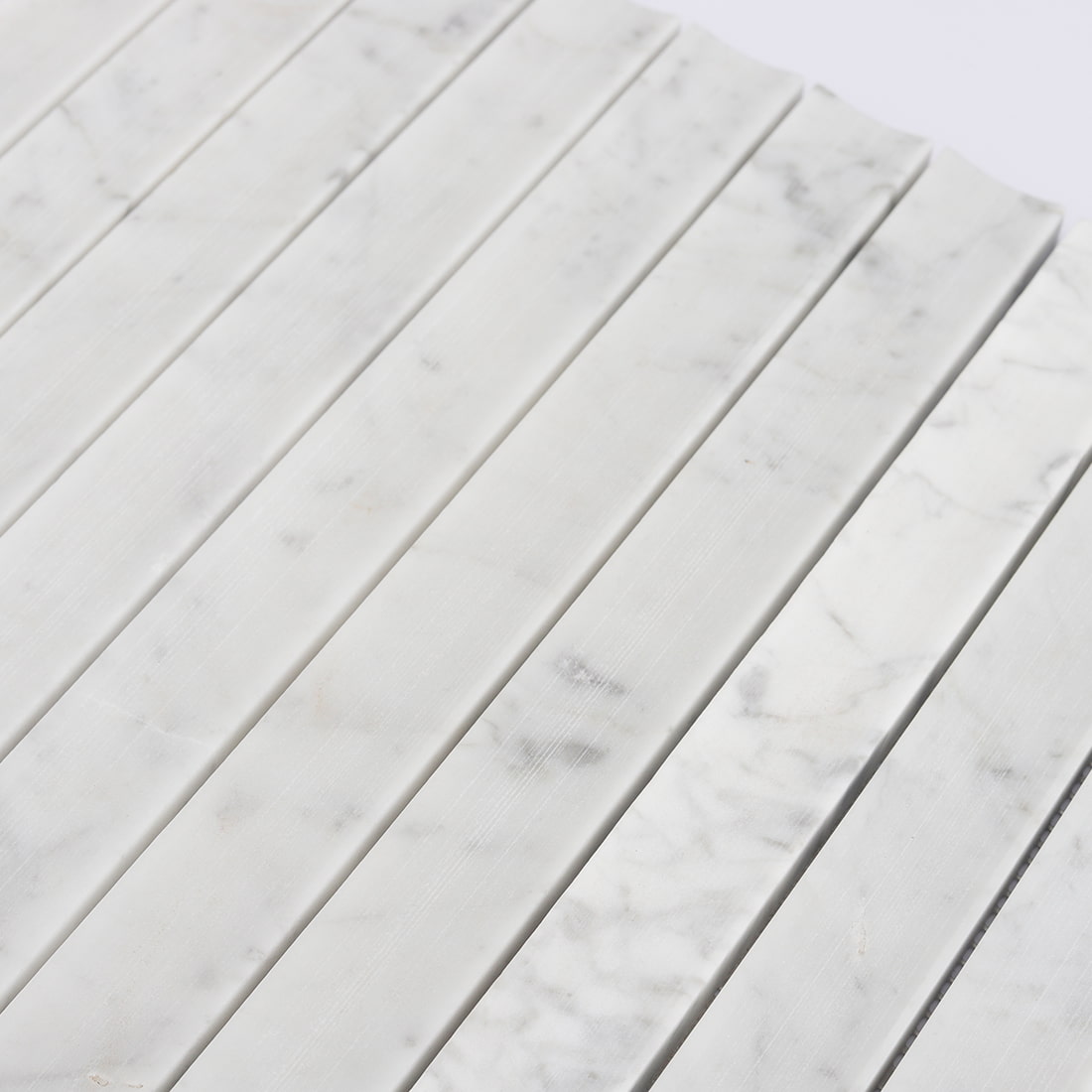 Close-up of white marble concave vertical mosaic tile surface