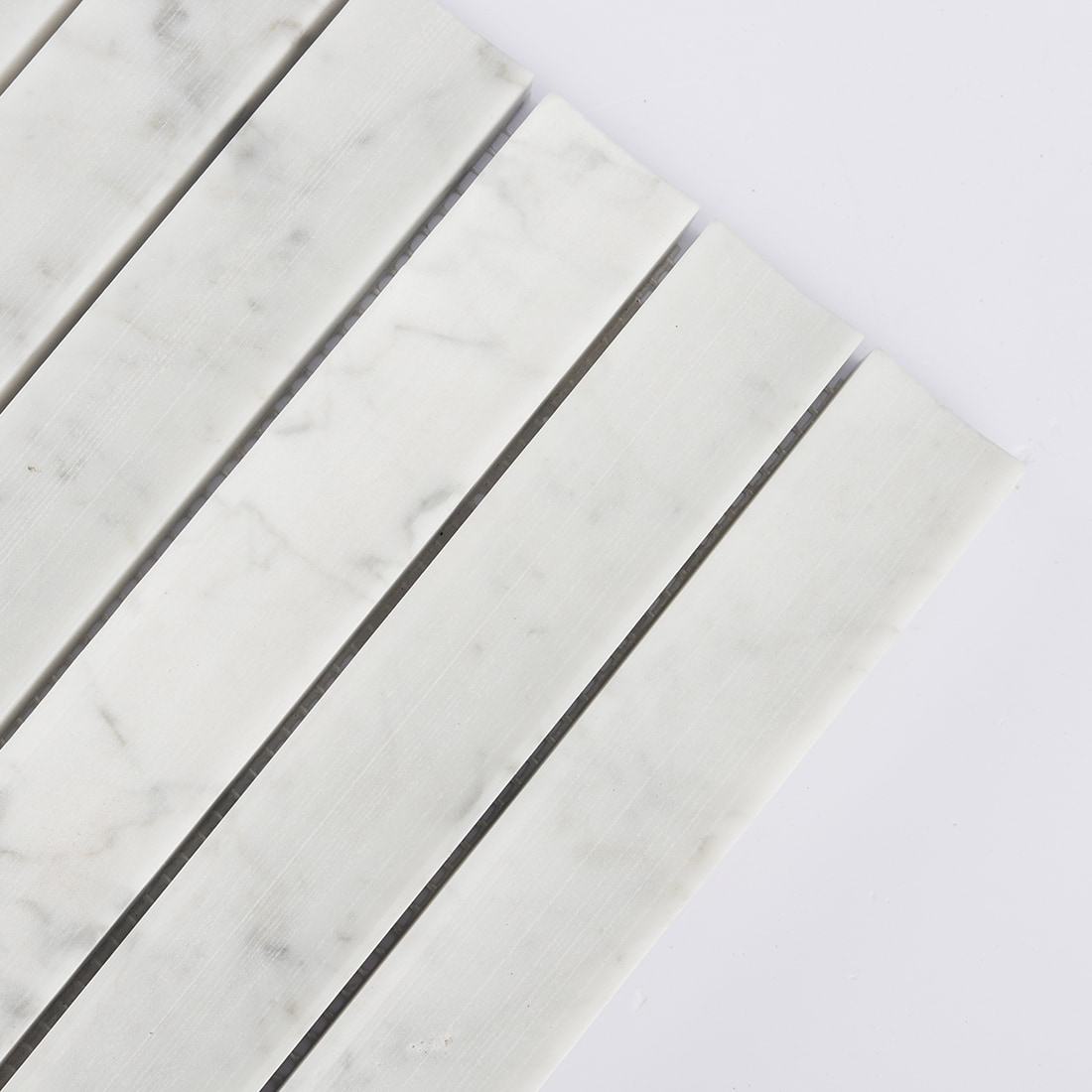 Corner detail of white marble concave vertical mosaic tile