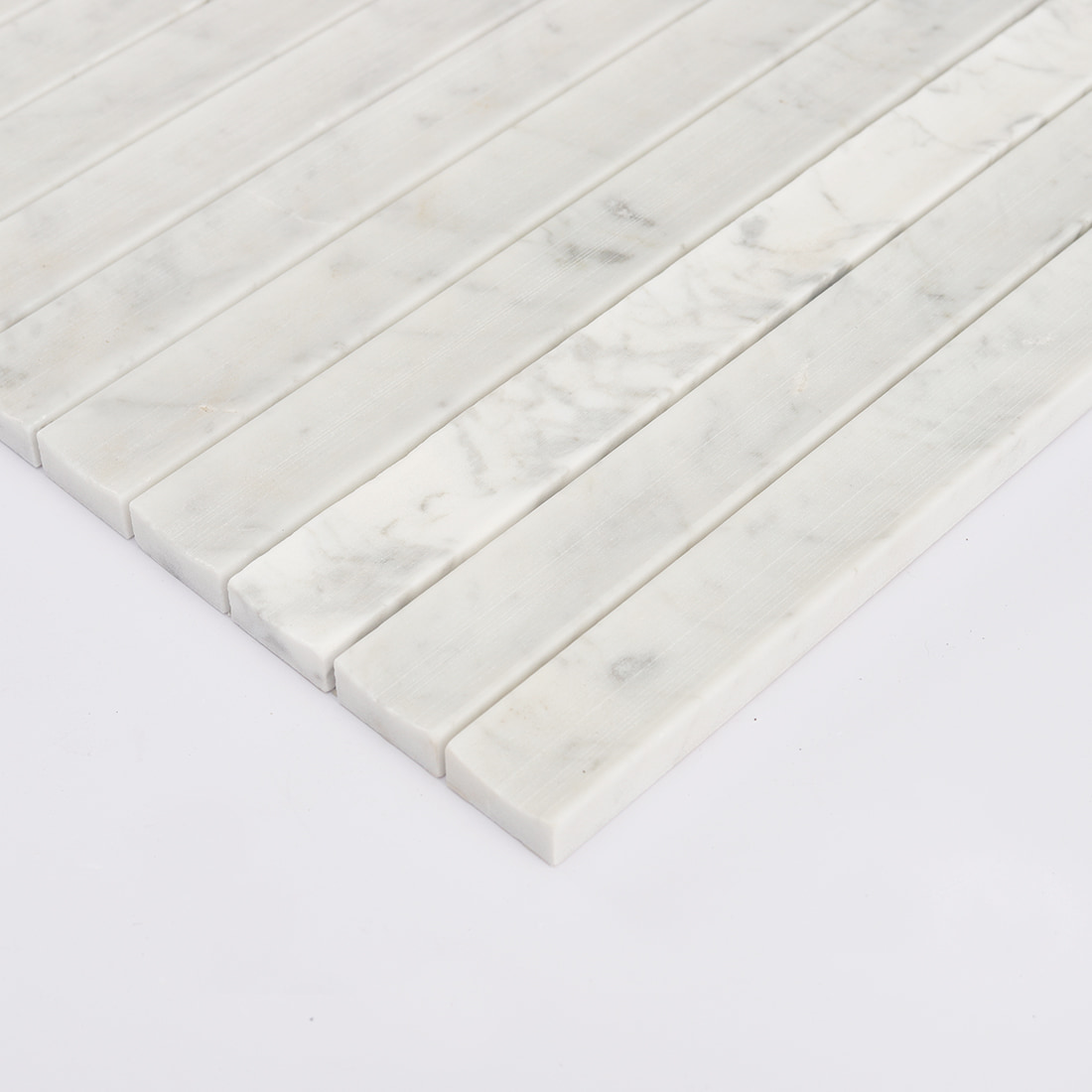 Angled edge view of white marble concave vertical mosaic tile