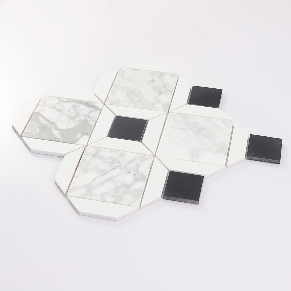 Low angle display of white marble diamond mosaic tile with raised black pieces