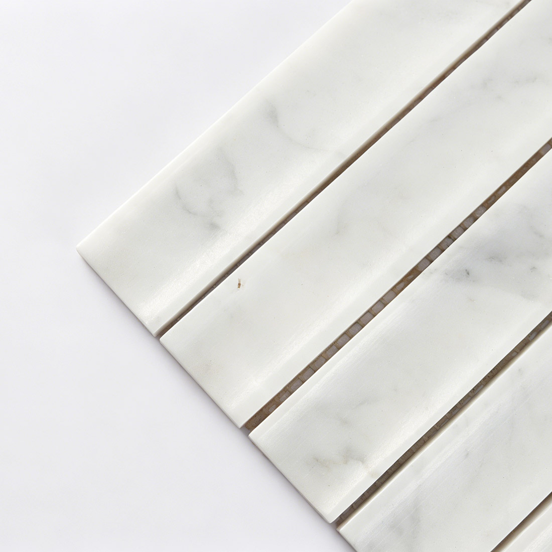 Corner detail showing curved white marble fluted tile.
