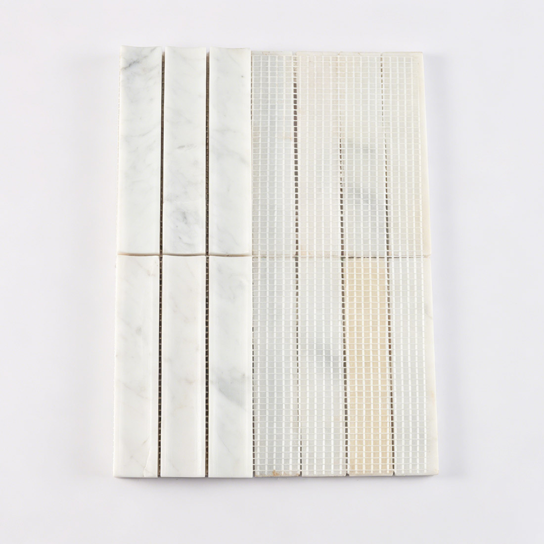 Mesh backing on white marble fluted linear tile.
