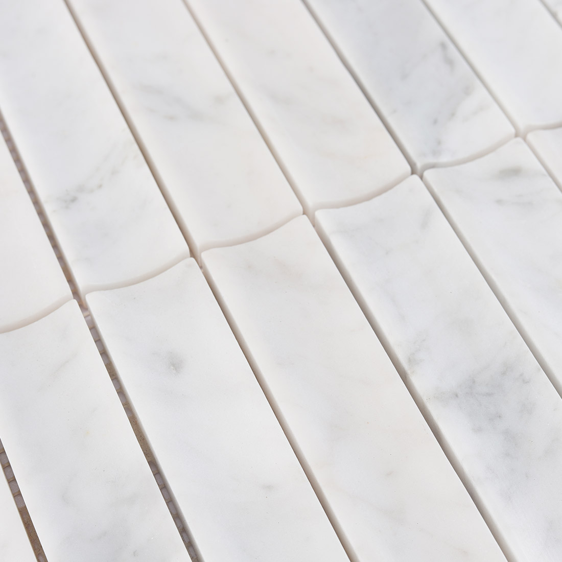Surface texture and grey veins of white marble fluted tile.