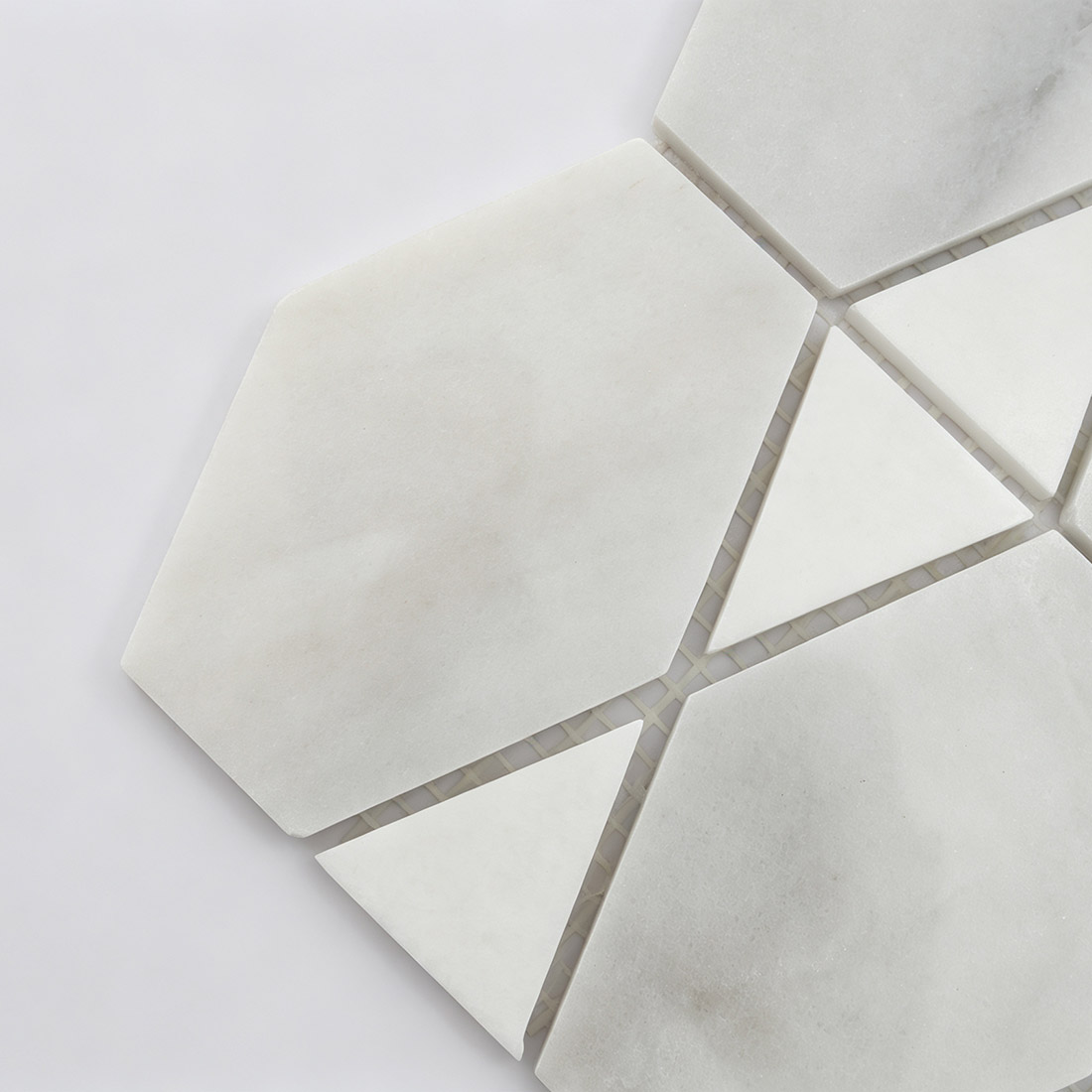Close-up of white marble geometric mosaic tile with triangular accents