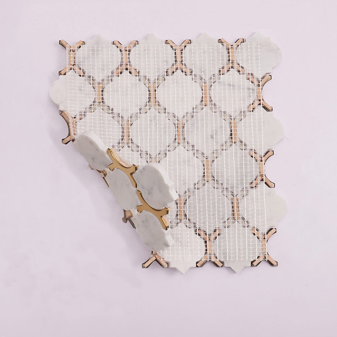 Back view of white marble and gold metal arabesque mosaic with mesh backing