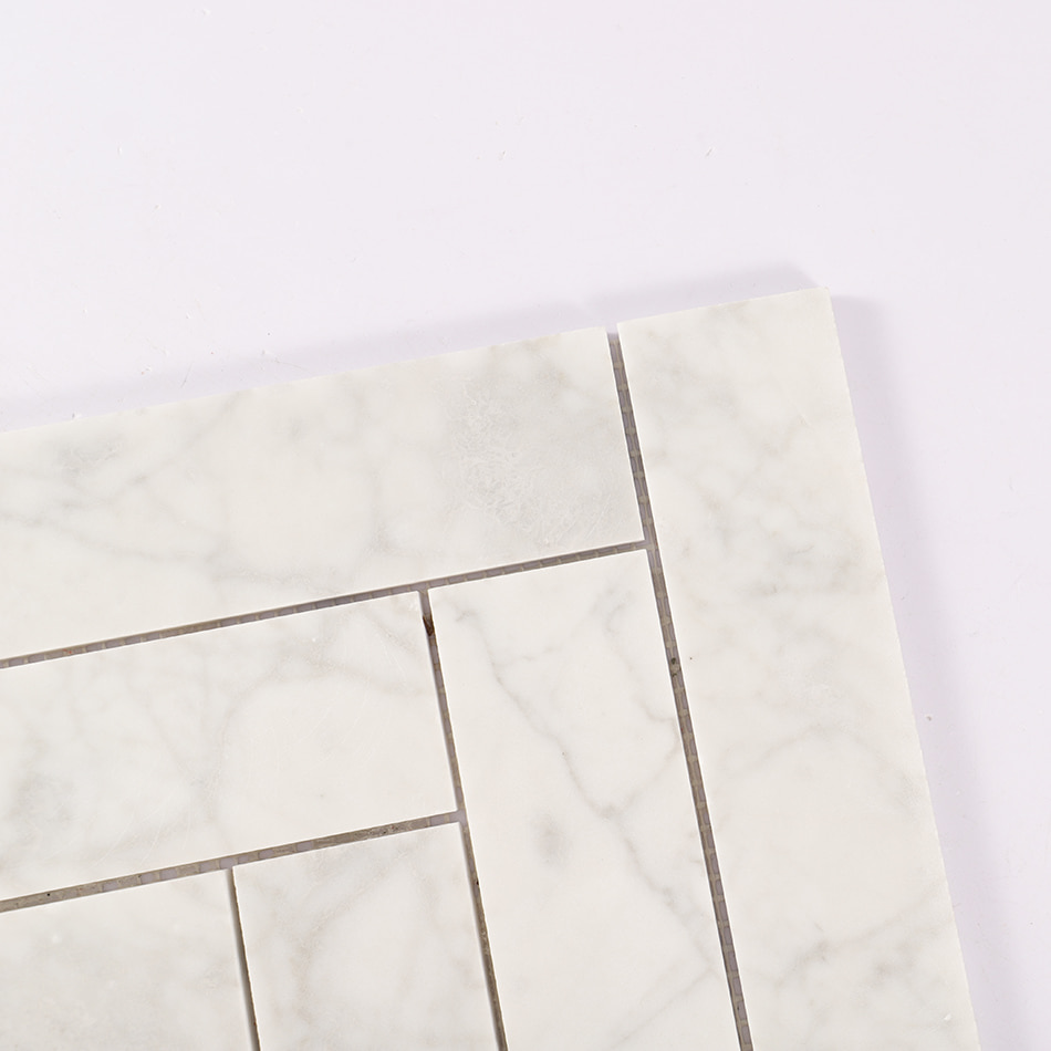 Corner detail of white marble herringbone mosaic tile