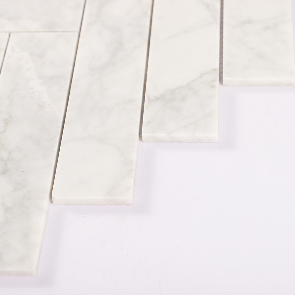 Edge detail of white marble herringbone mosaic tile