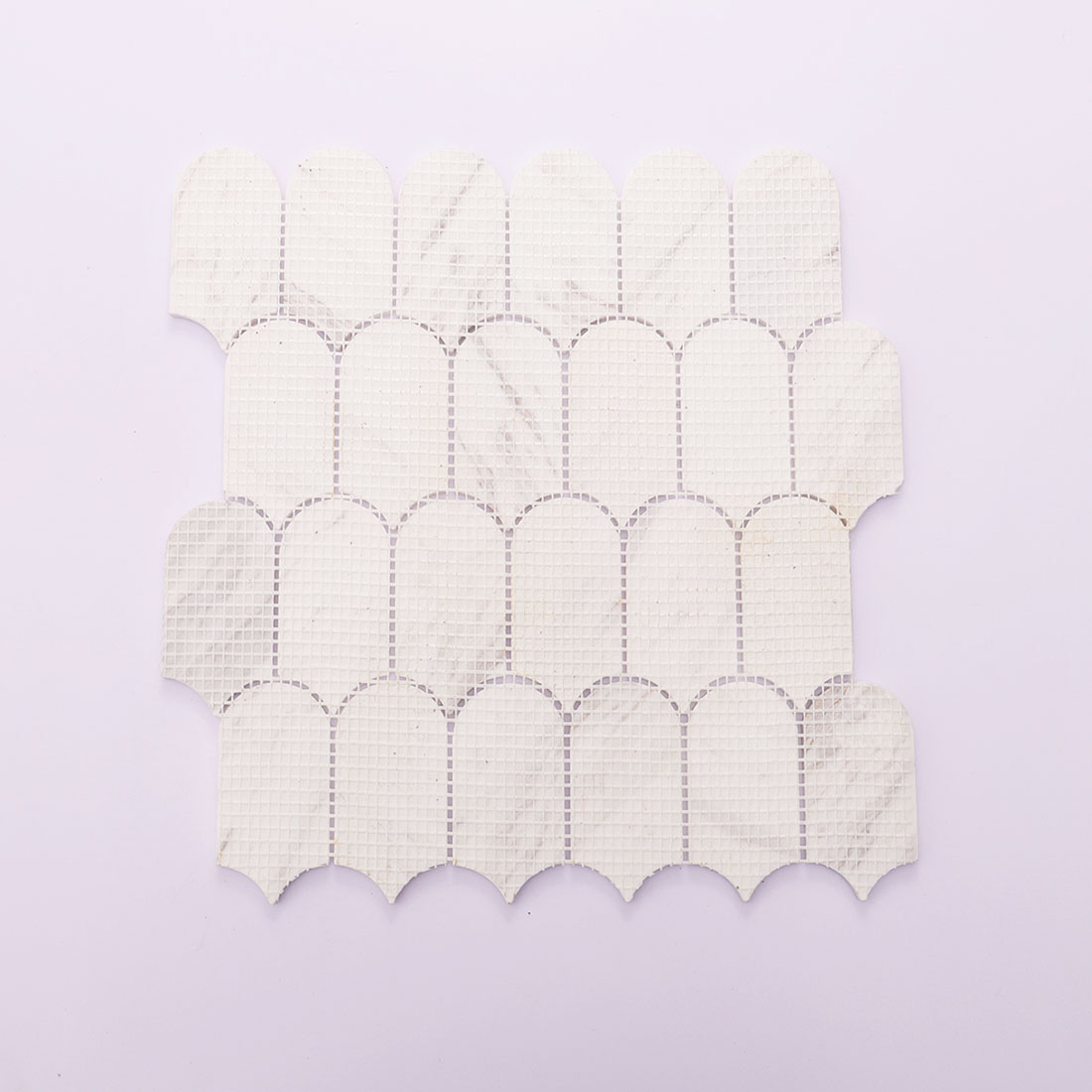 White mesh backing on the reverse side of marble mosaic tile