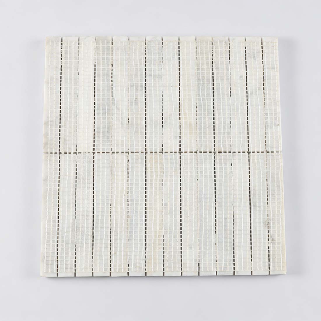 Professional mesh-mounted backing of white marble rod mosaic tile.