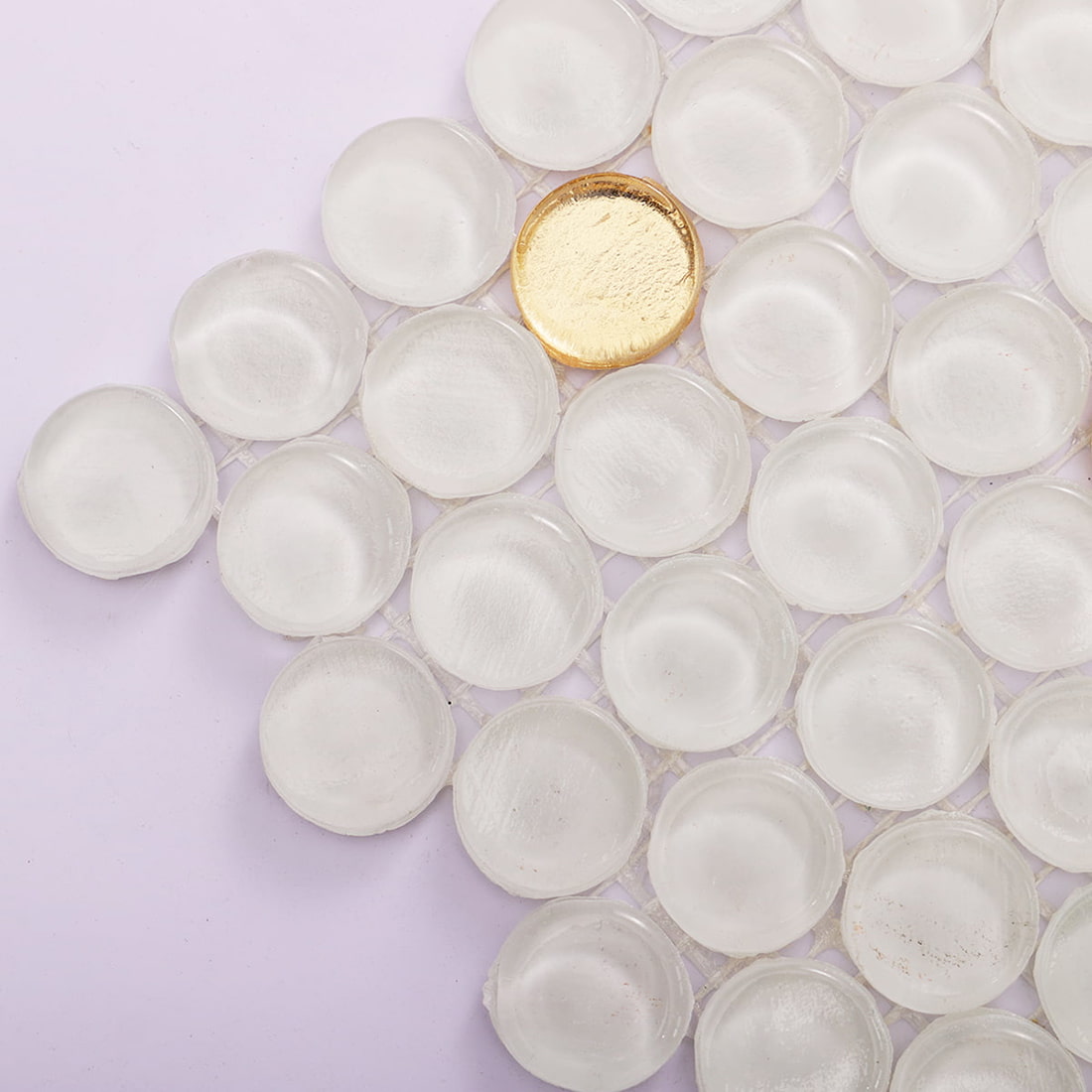Close up of white penny round glass mosaic tile with gold foil accent pieces