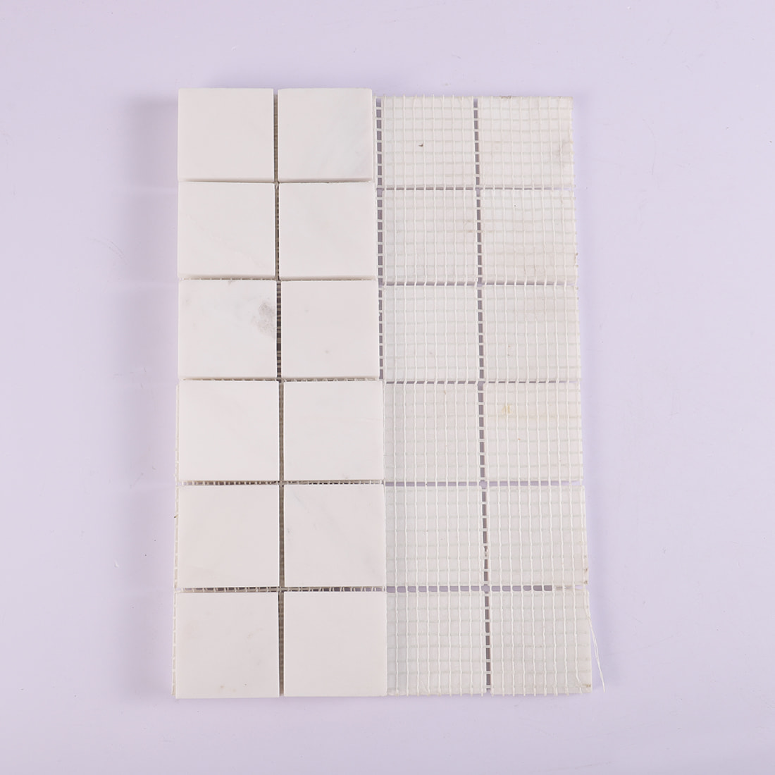 Back view of white square marble mosaic tile with mesh backing