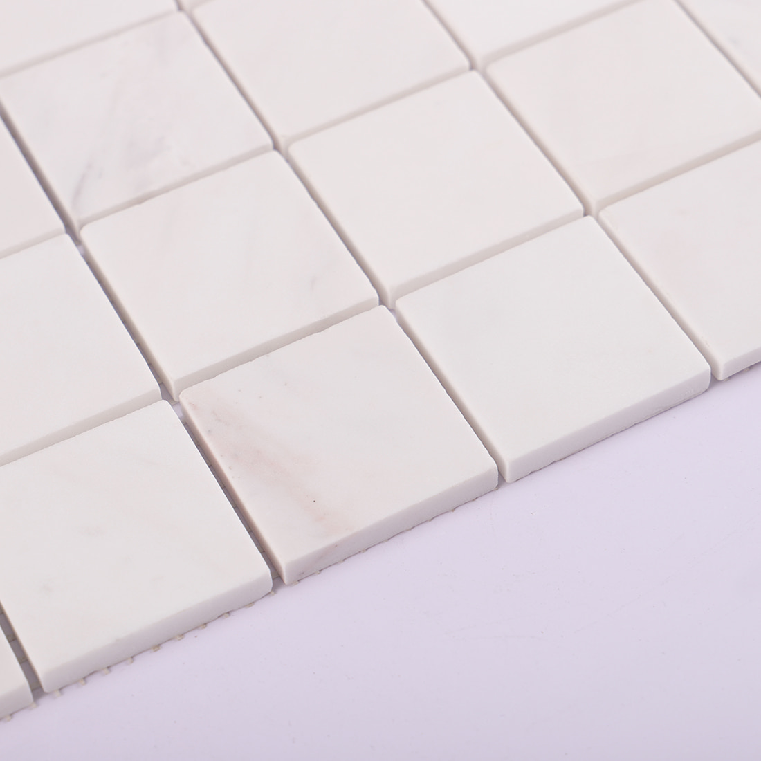 Edge detail of white square marble mosaic tile sheet