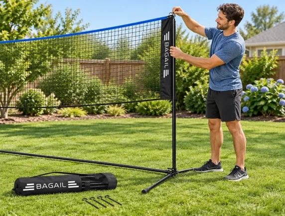 One person hooking the top corner of the net onto the post during a solo setup on a driveway